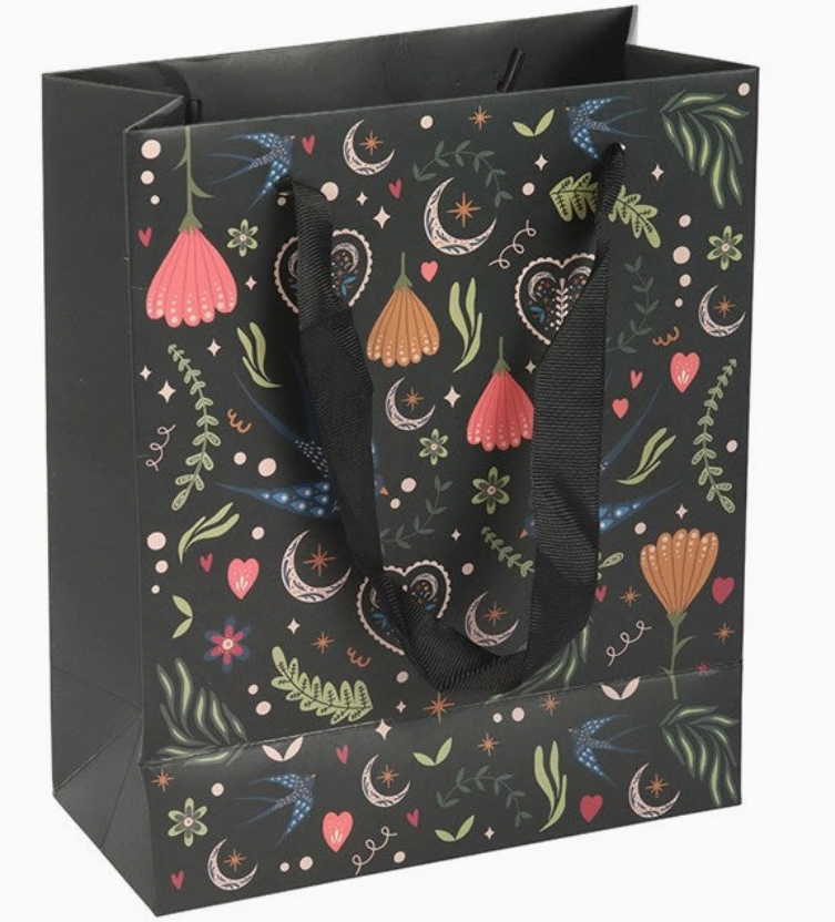 Gift bag with colorful floral and moon pattern on a black background