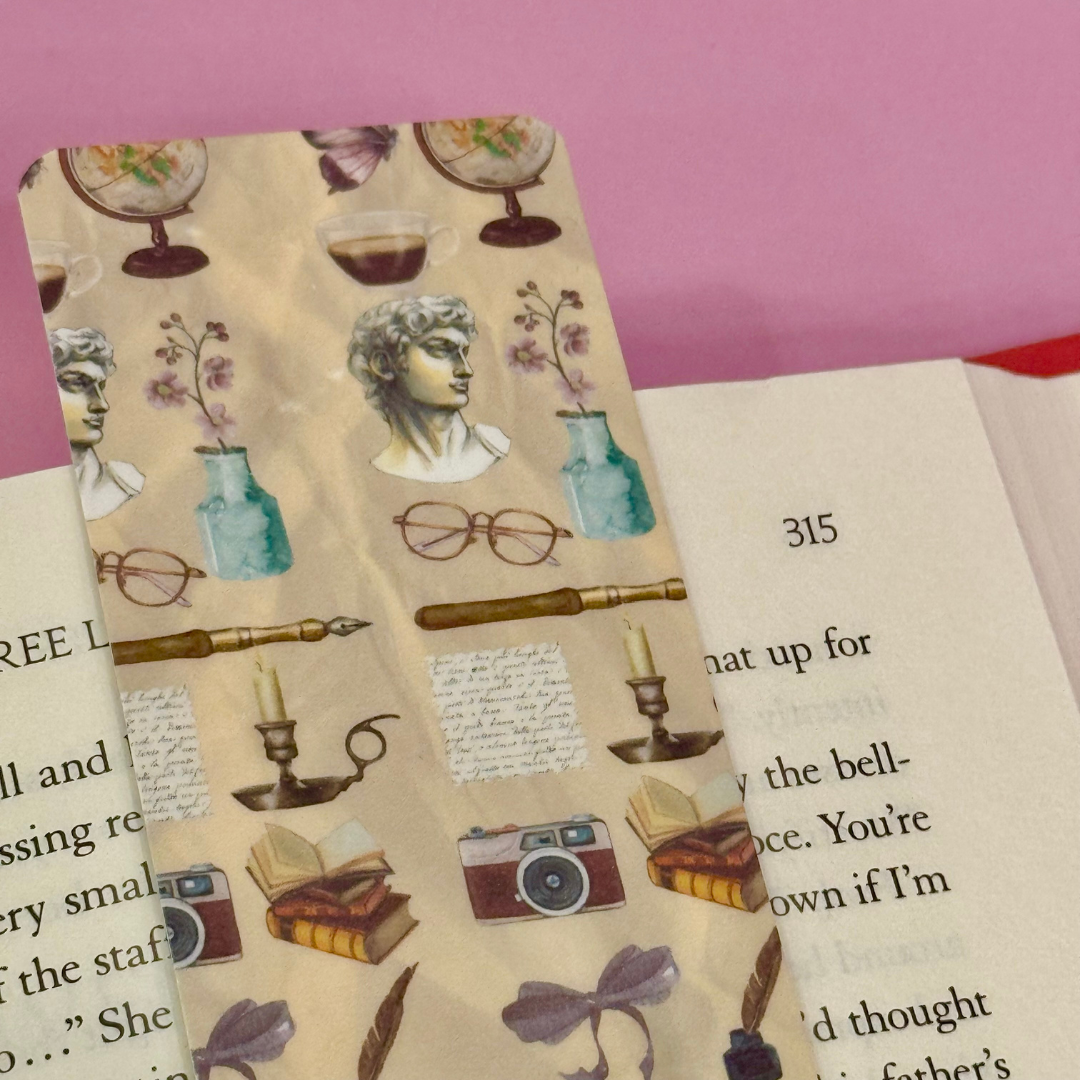 Decorative bookmark with vintage illustrations on a book page.