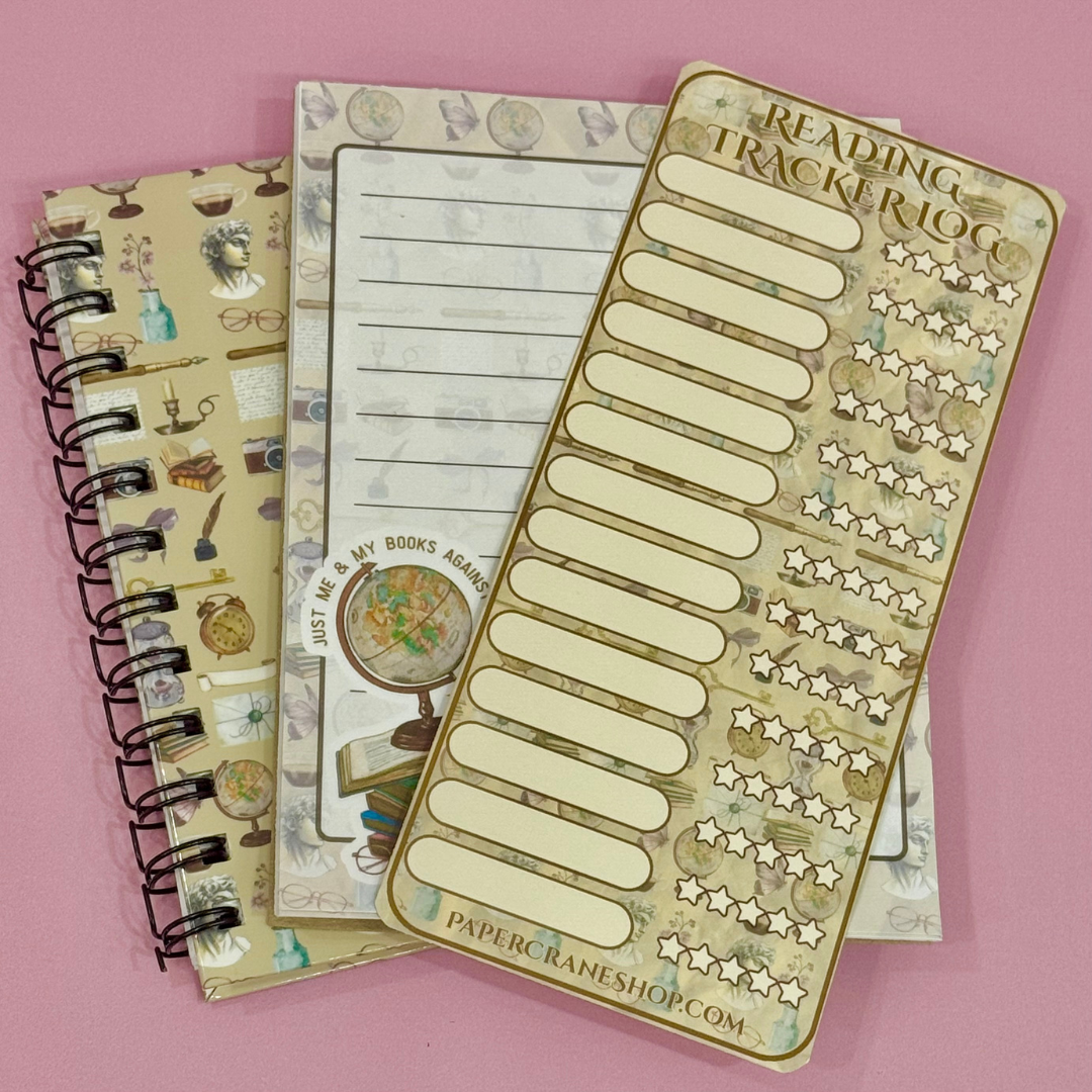 Notebook with reading tracker and decorative cover on a pink background