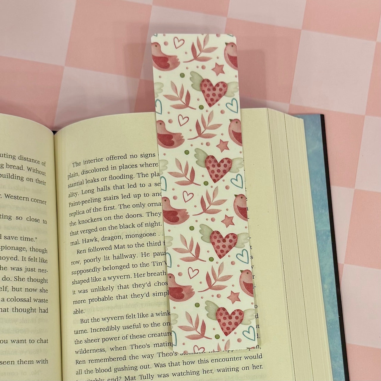 Book with a decorative bookmark on a pink checkered background