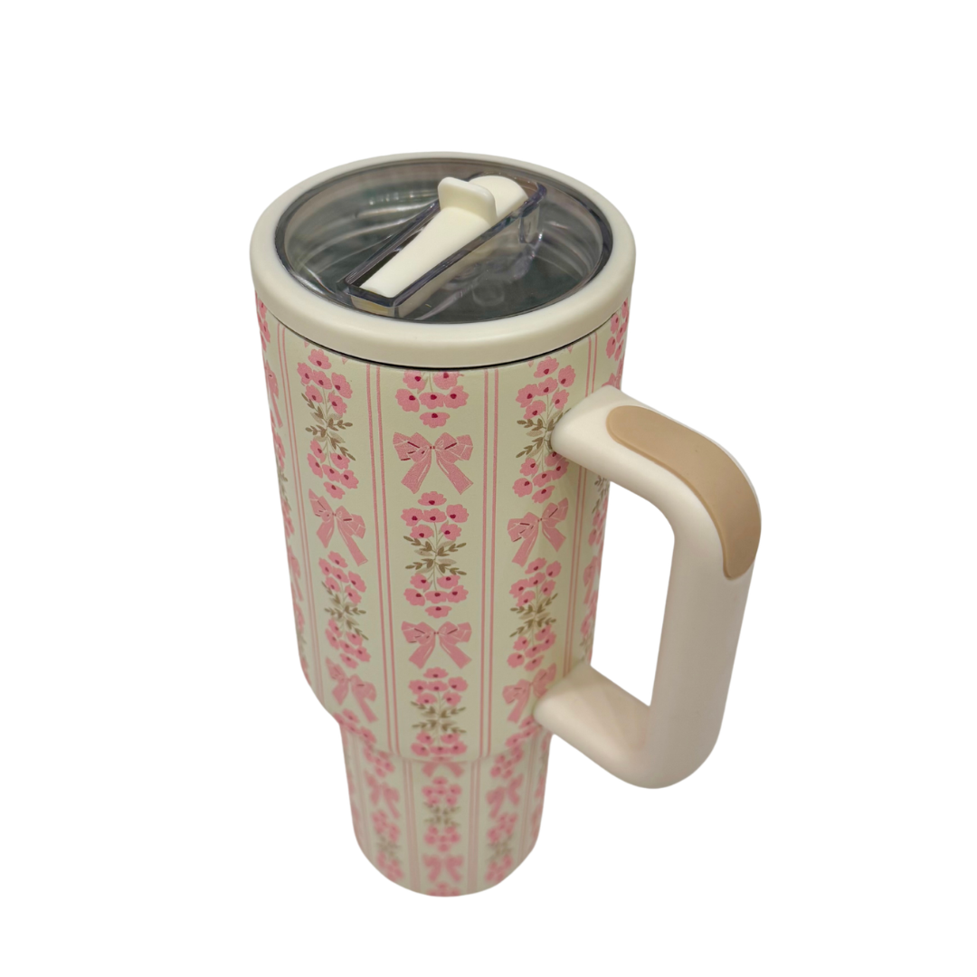 Travel mug with floral design and handle on a white background