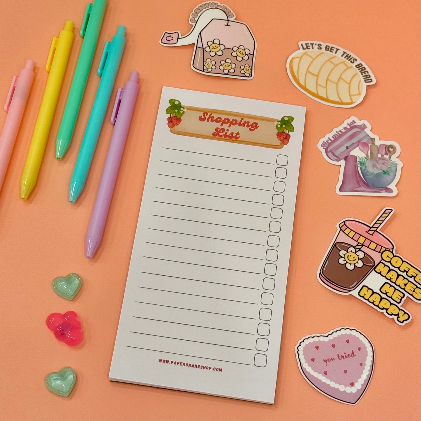 Notepad with 'Shopping List' on a colorful background with pens and stickers
