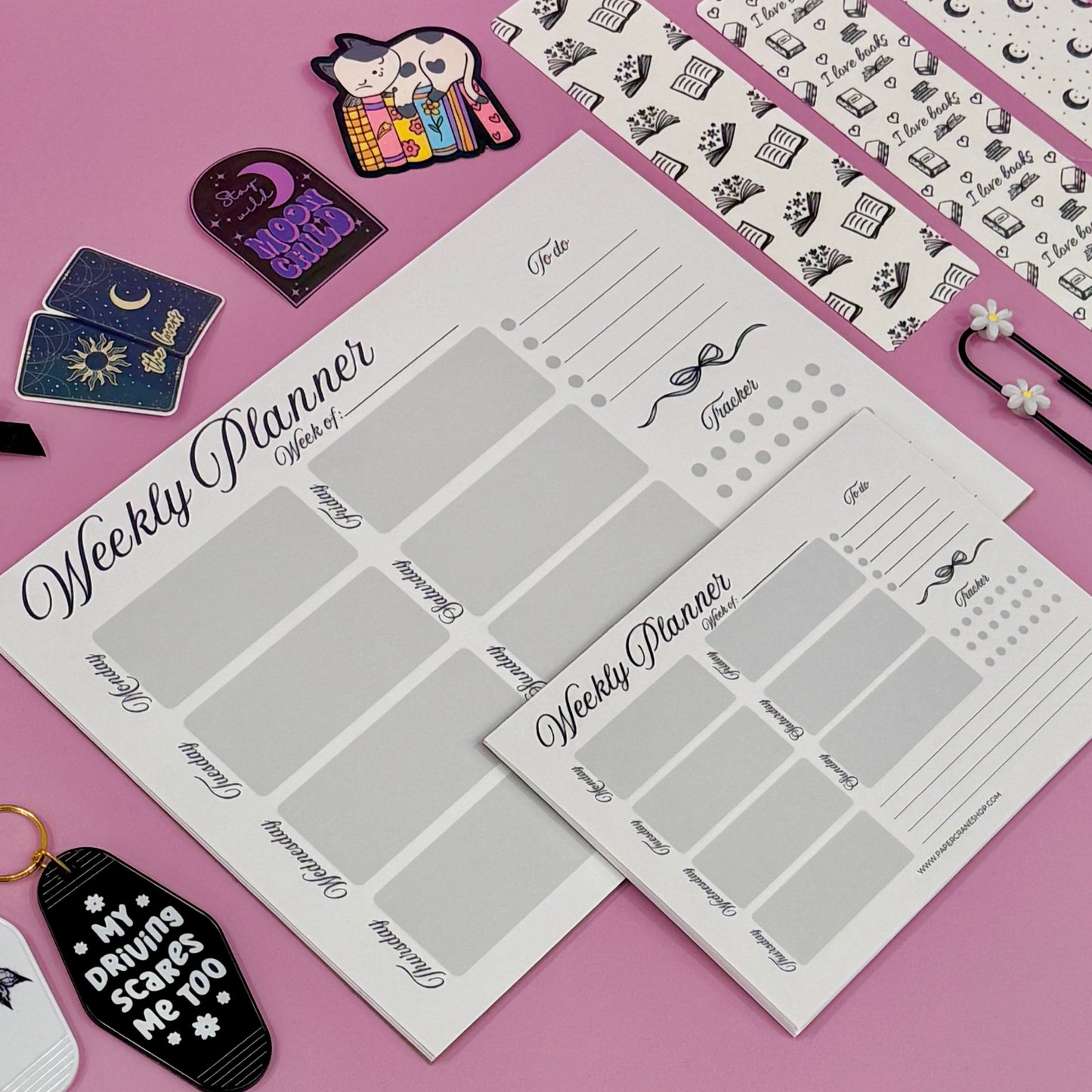 Weekly planner sheets on a pink background with decorative items.
