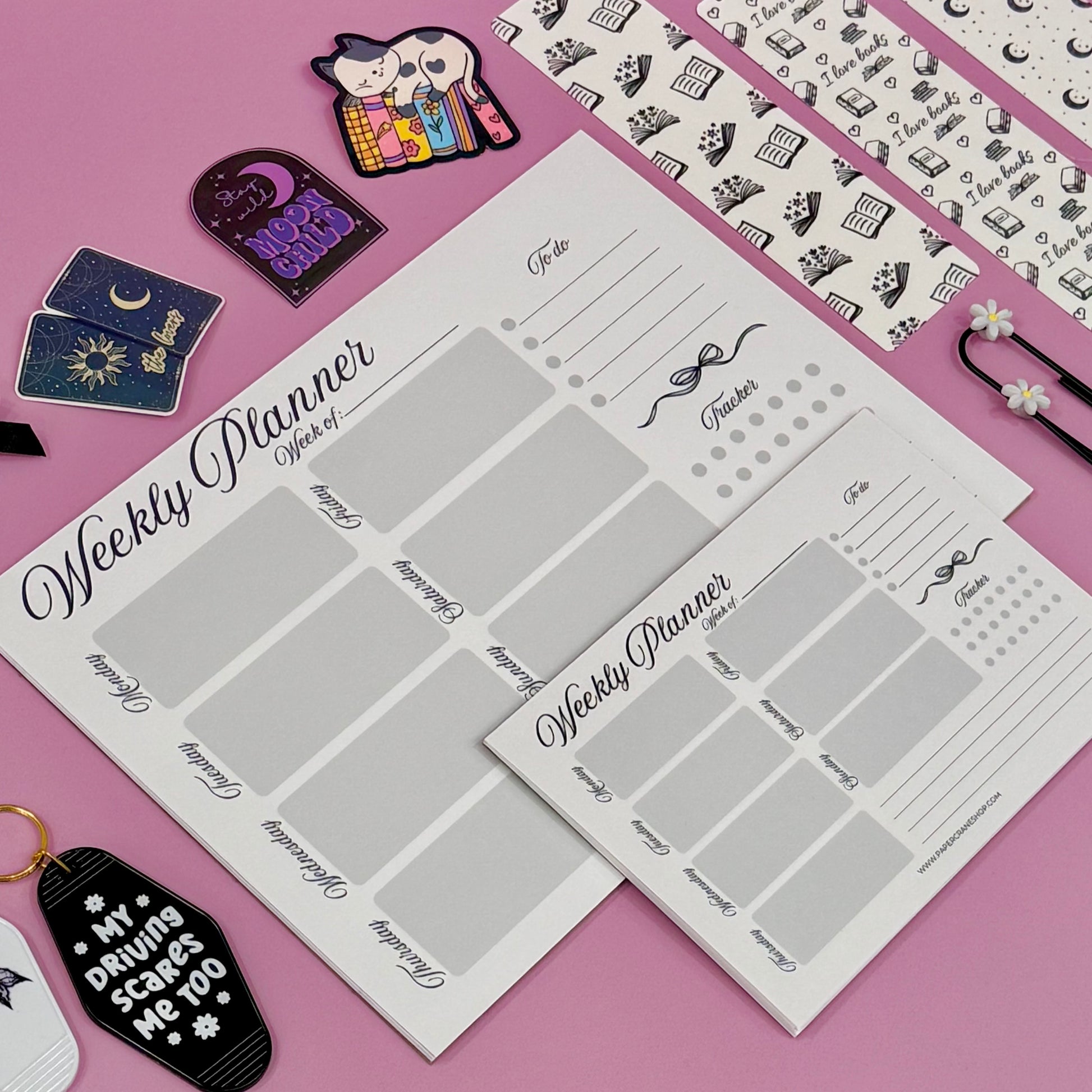 Weekly planner sheets on a pink background with decorative items.
