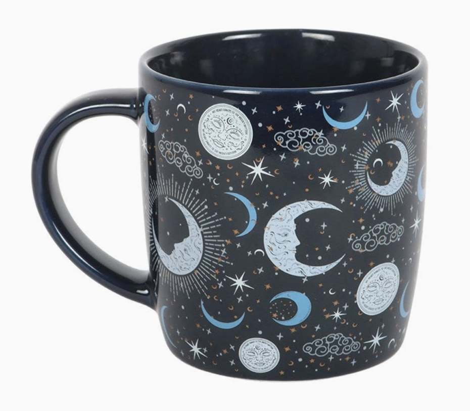 Mug with celestial design featuring moons, stars, and clouds on a dark background