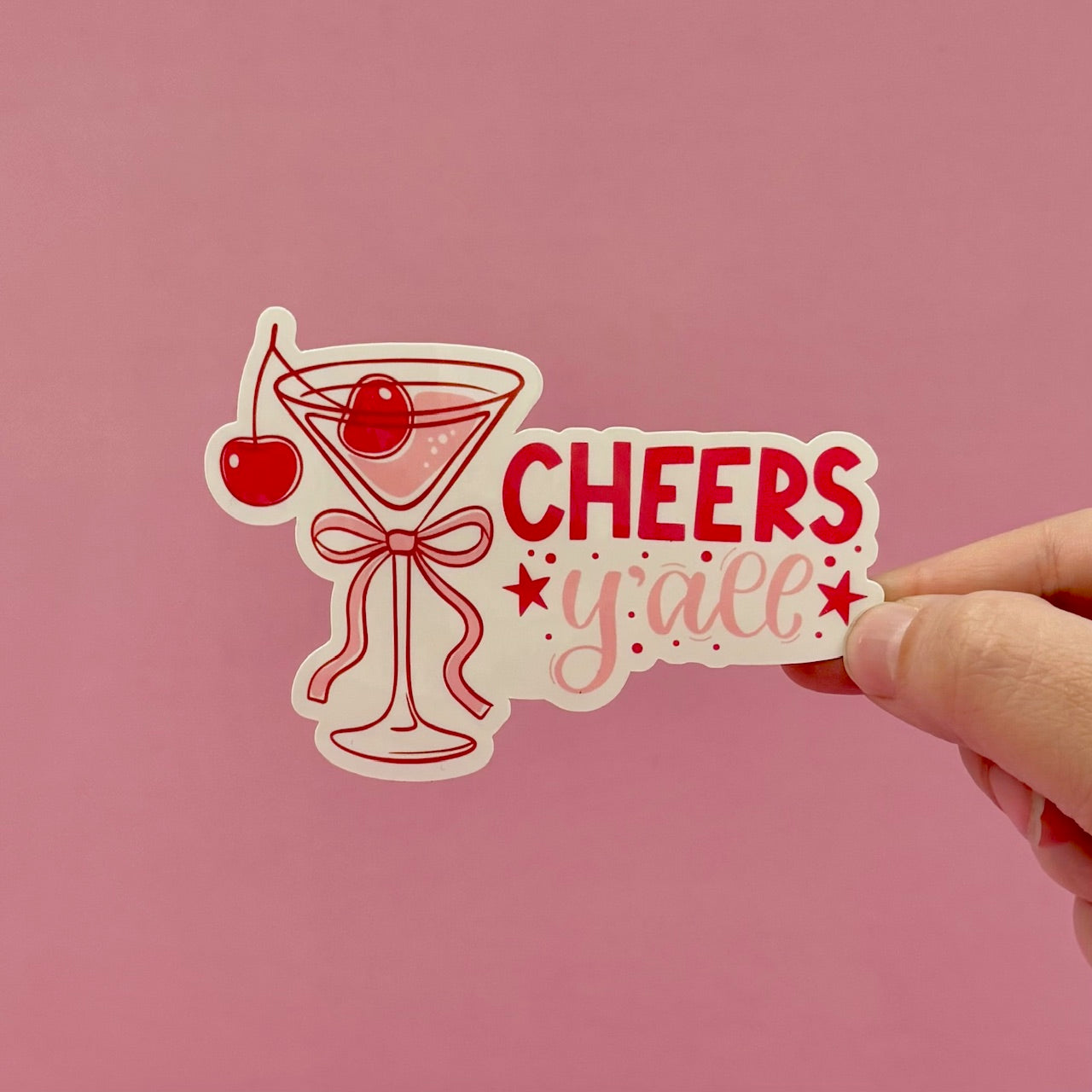 Sticker with a cocktail glass and cherry design on a pink background