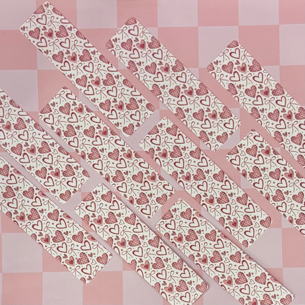 Set of heart-patterned bookmarks on a pink checkered background