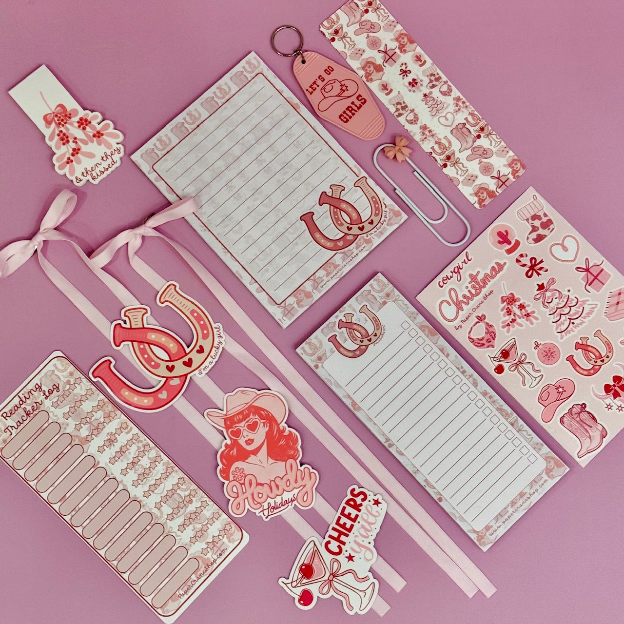 Collection of pink stationery items on a pink background