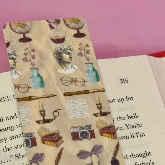 Decorative bookmark with vintage illustrations on a book page.