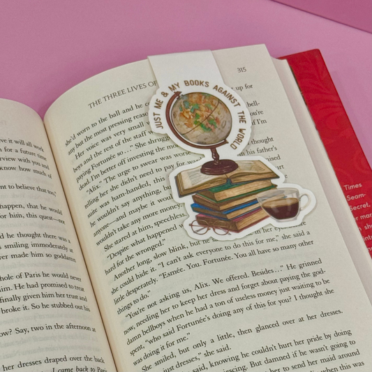 Open book with a decorative bookmark featuring books, a globe, and a cup on a pink background