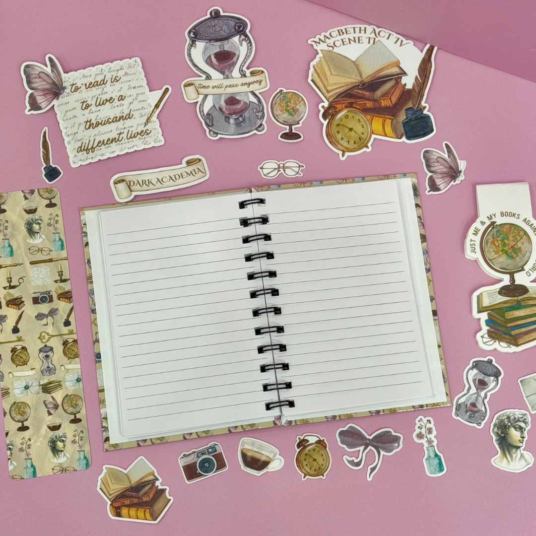 Open notebook with lined pages on a pink background with various stickers around it.