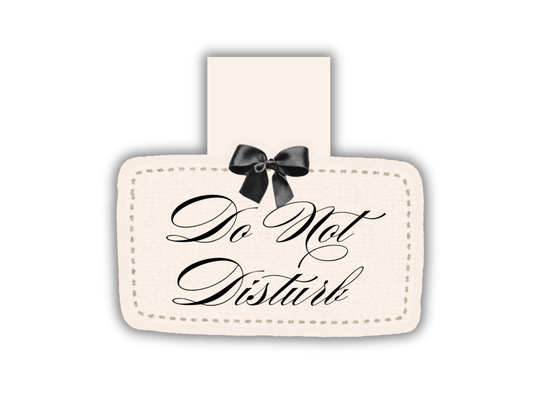 A rectangular cream-colored magnetic bookmark with a stitched border, black cursive text reading 'Do Not Disturb,' and a black bow at the top, shown on a plain white background.