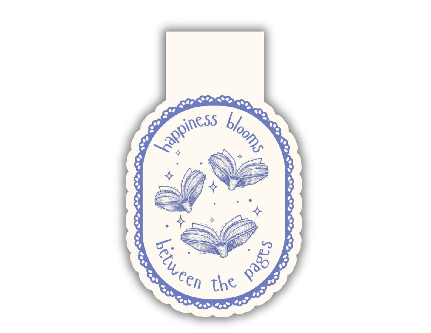 A magnetic bookmark with a cream background and blue decorative border, featuring three open books and the text 'happiness blooms between the pages'.