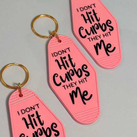 Pink keychains with black text on a gray background