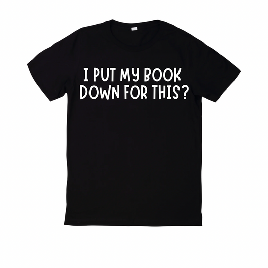Black t-shirt with white text 'I PUT MY BOOK DOWN FOR THIS?' on a white background