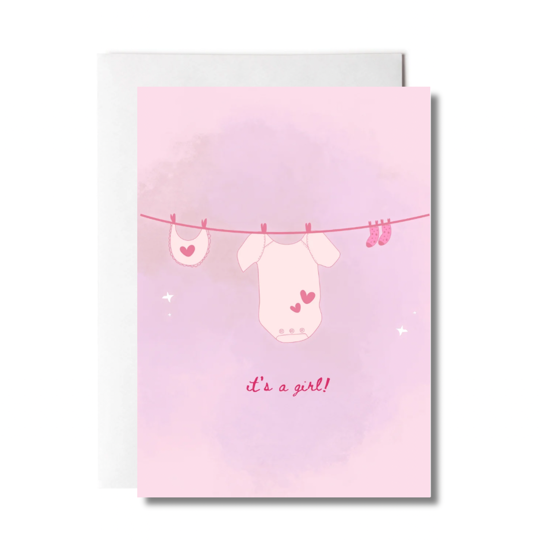 greeting card with baby clothes on a clothes lines that says "it's a girl"