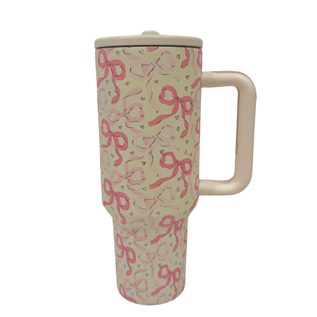 Travel mug with pink bow pattern on a white background