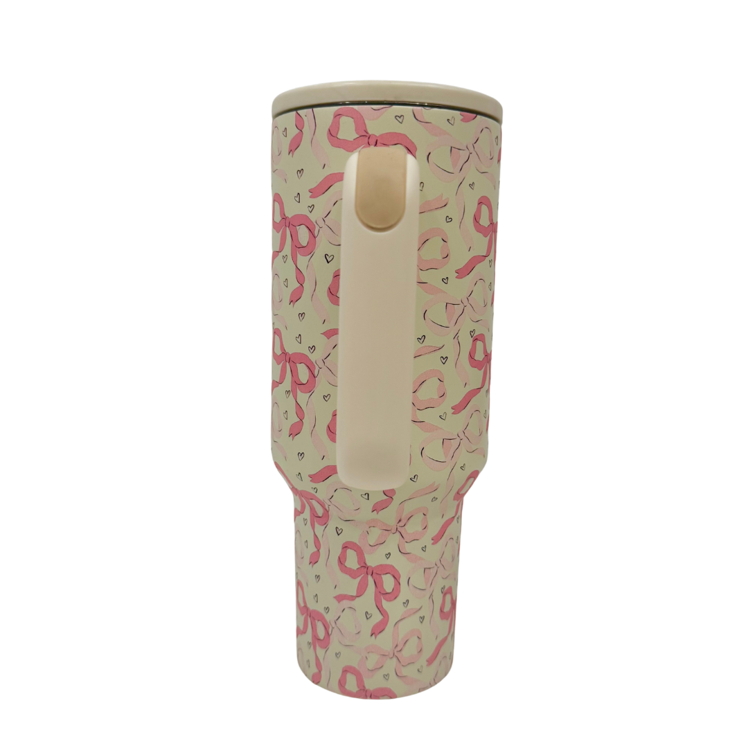 Travel mug with pink ribbon pattern on a white background