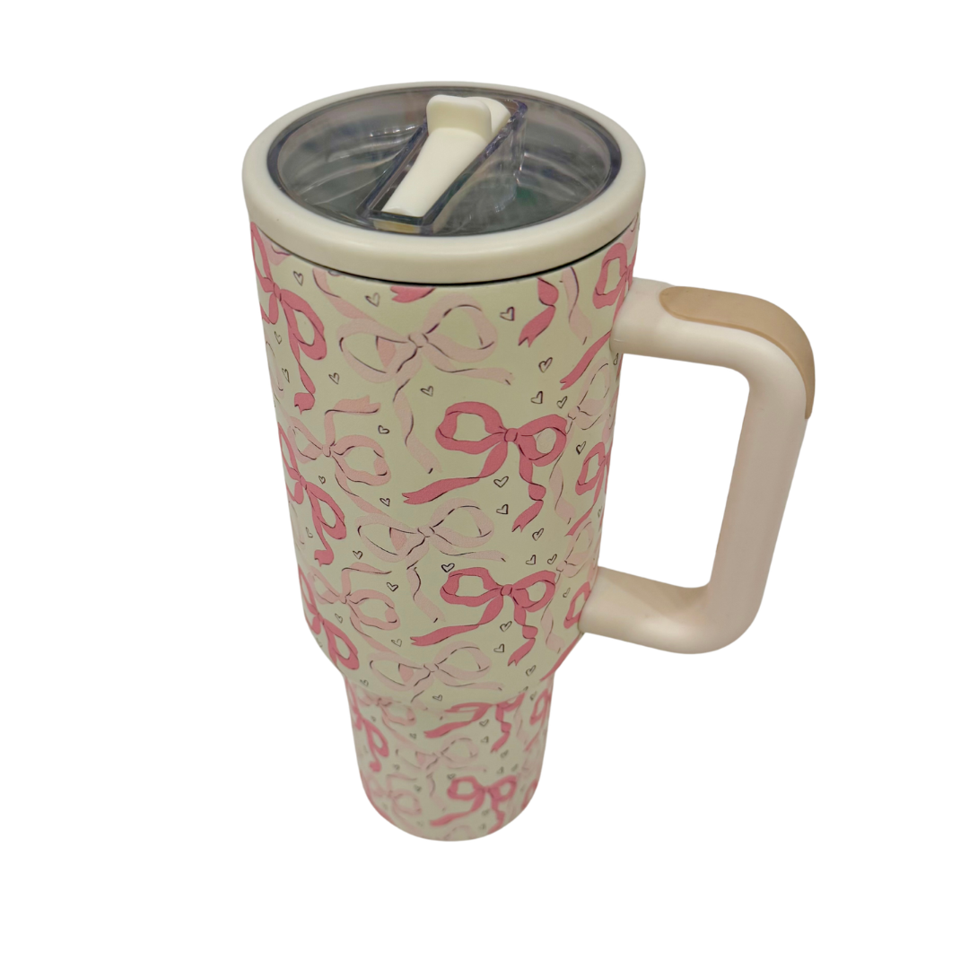 Travel mug with pink ribbon pattern on a white background