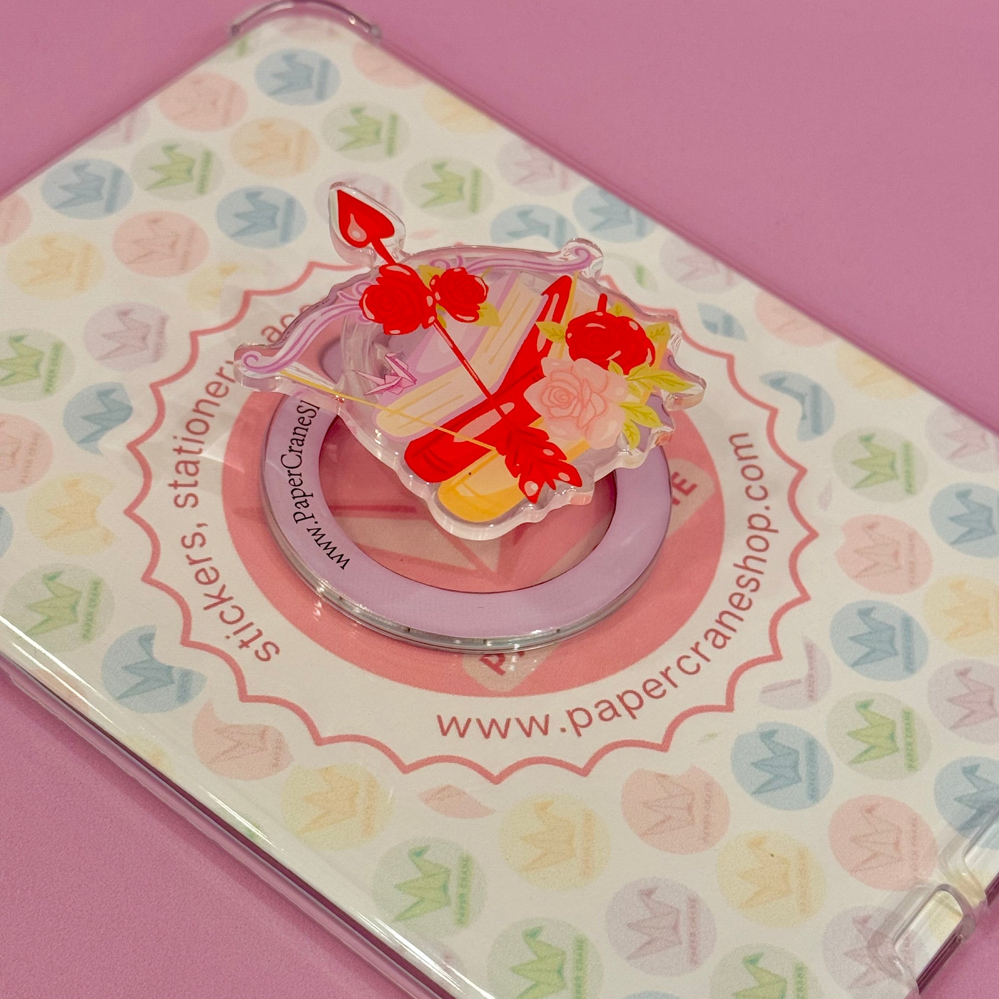 Decorative magsafe phone holder with a colorful design with books, roses and bow and arrow