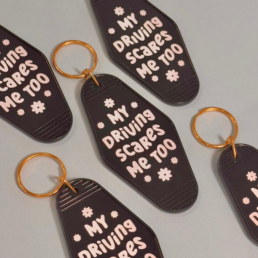 Black keychains with 'My Driving Scares Me Too' text on a gray background