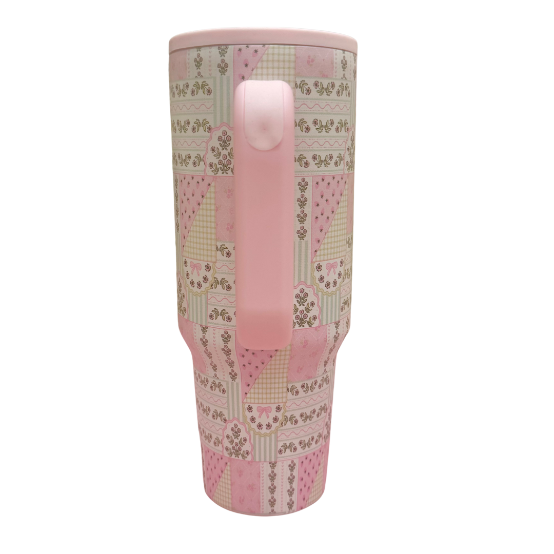Tumbler with pink and patterned design on a white background