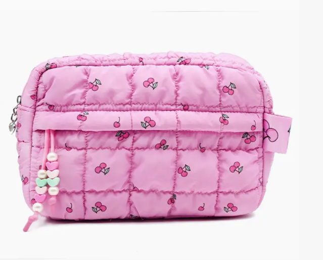 Pink quilted bag with cherry pattern on a white background