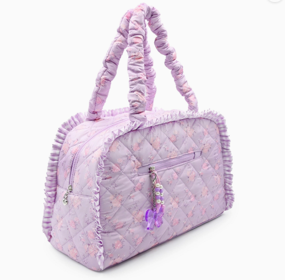 Purple quilted handbag with ruffled handles on a white background