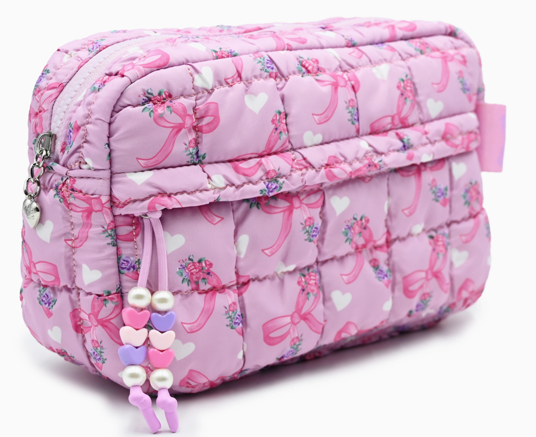 Pink quilted cosmetic bag with bow pattern on a white background