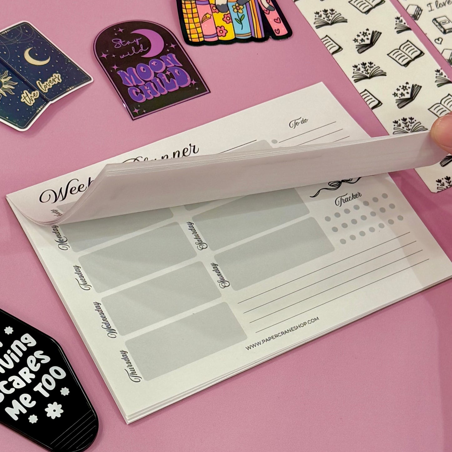 Planner stickers with text and graphics on a pink surface