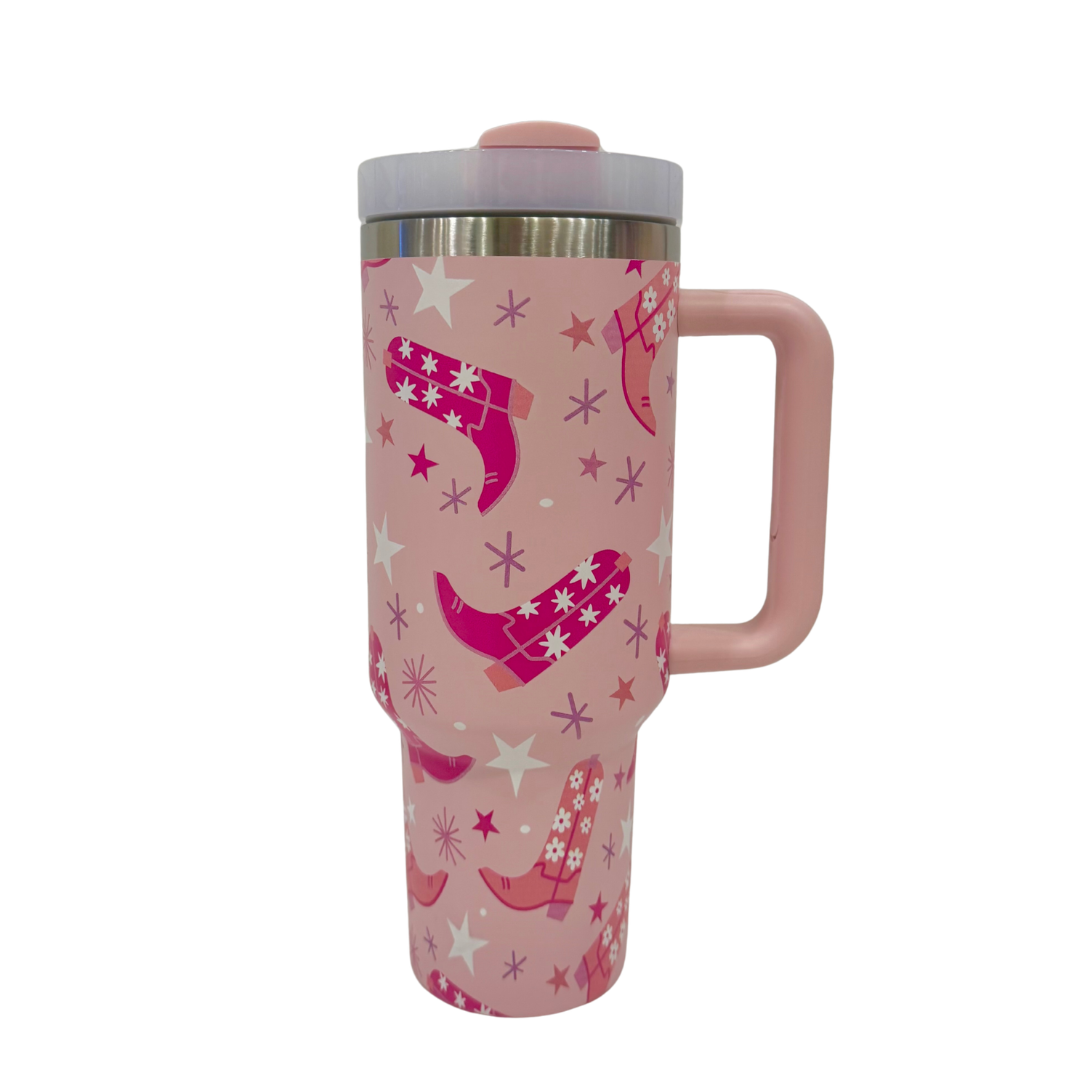 Pink travel mug with cowboy boot and star pattern on a white background