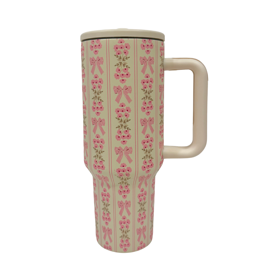 Travel mug with pink bow pattern on a white background