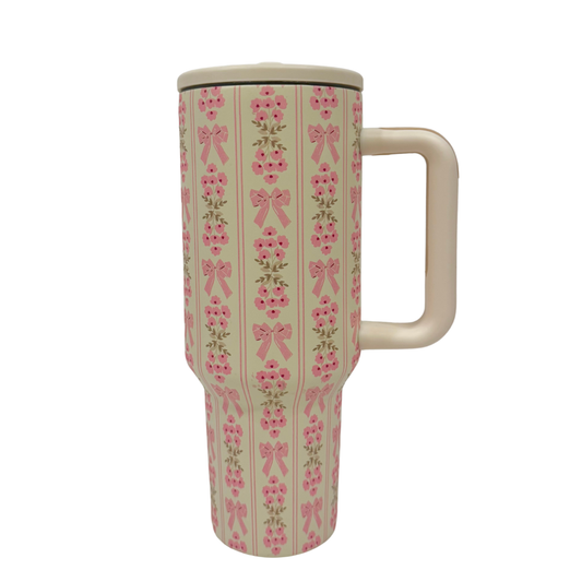 Travel mug with pink bow pattern on a white background