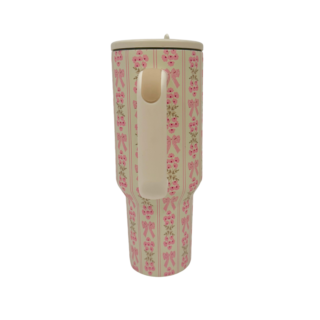 Tumbler with pink bow and floral pattern on a white background
