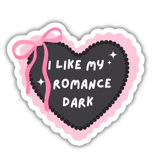 Heart-shaped sticker with pink ribbon and text 'I LIKE MY ROMANCE DARK' on a white background