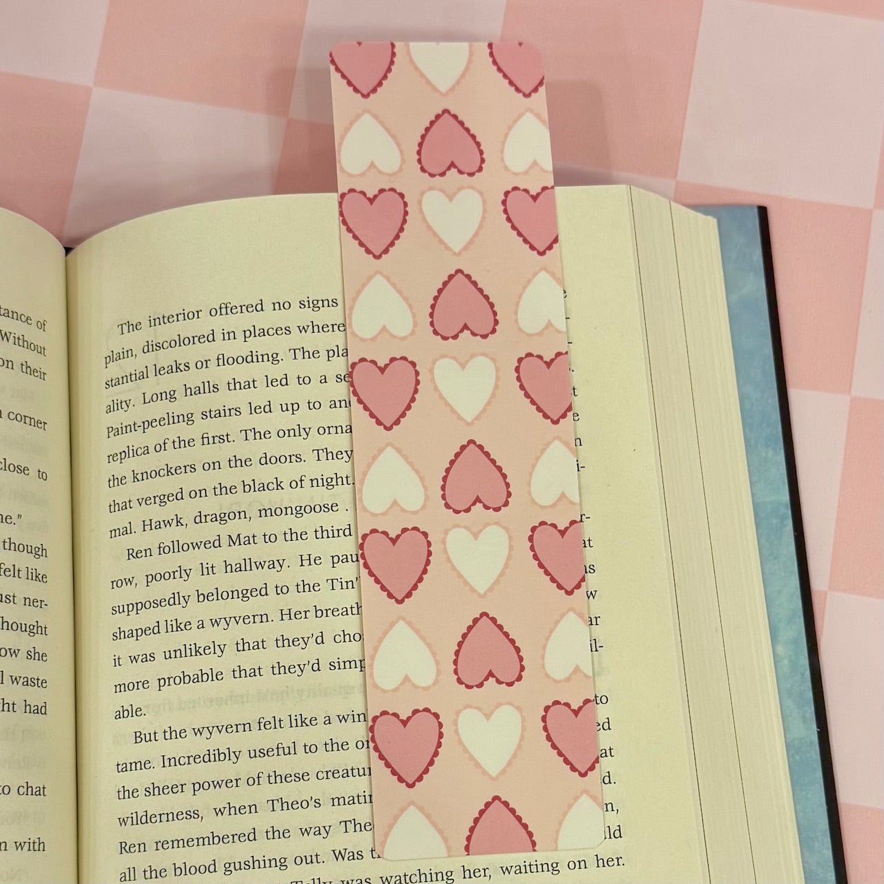 Book with a pink heart-patterned bookmark on a checkered background