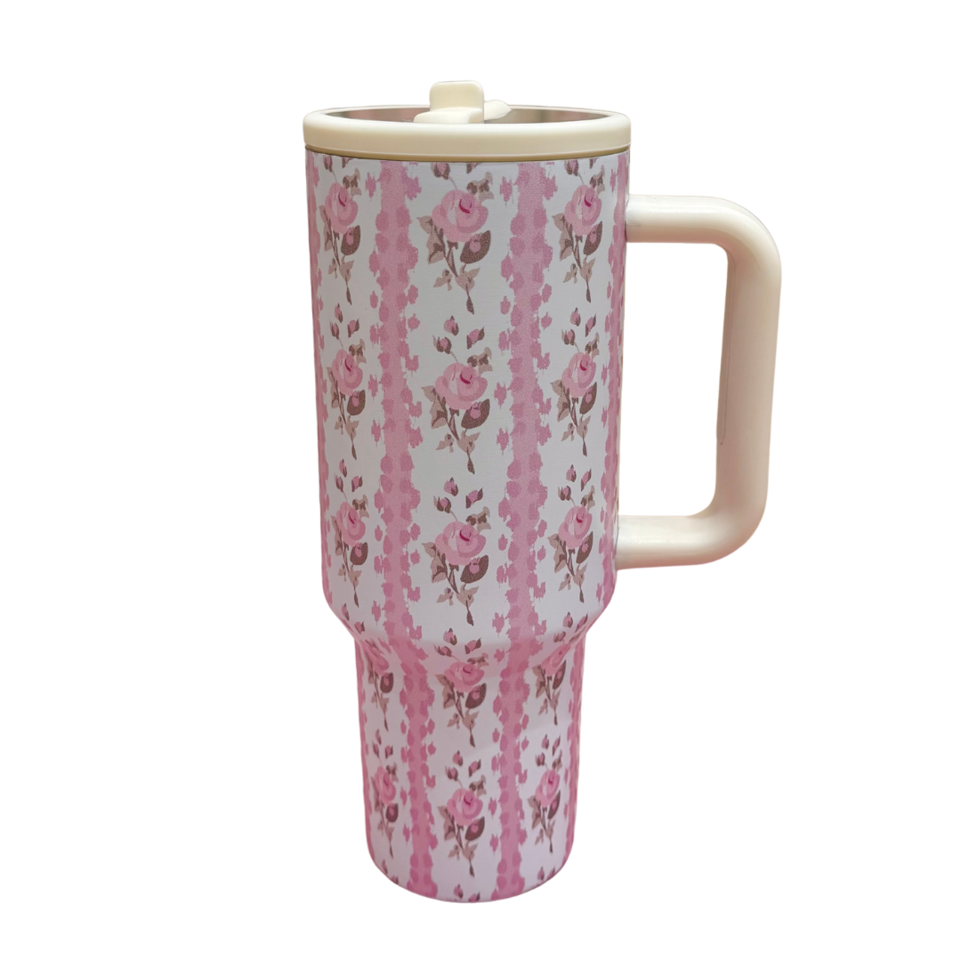 Floral-patterned tumbler with a handle on a white background