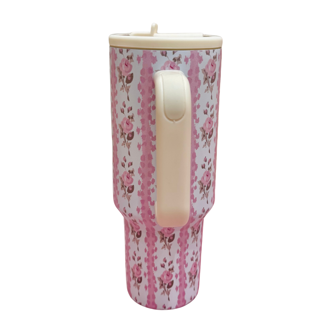 Floral-patterned tumbler with a handle on a white background