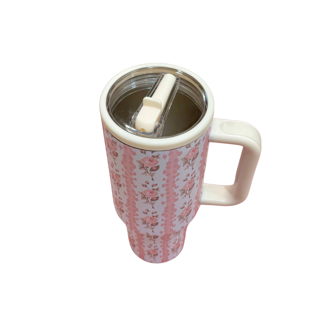 Floral-patterned tumbler with a straw on a white background